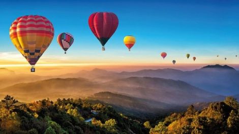 Colorful_hot_air_balloons_flying_over_mountain_at_Dot_Inthanon_in_Chiang_Mai,_Thailand._