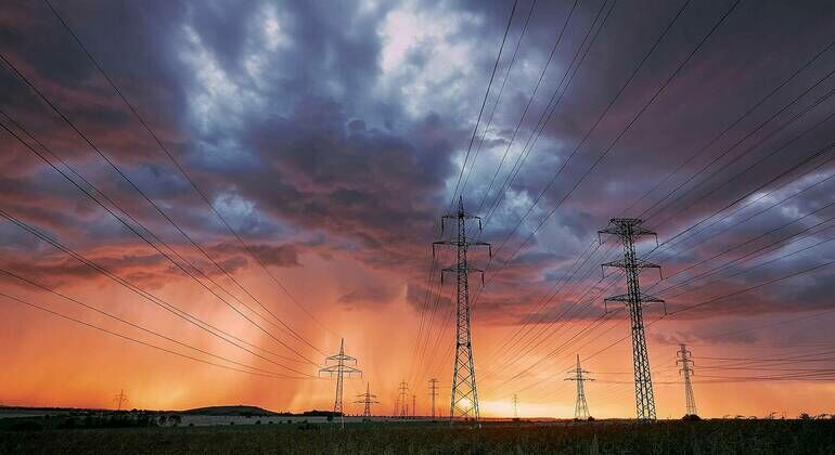 Extreme_weather._Electricity_pylons_with_power_lines_against_stunning_storm_at_sunset.