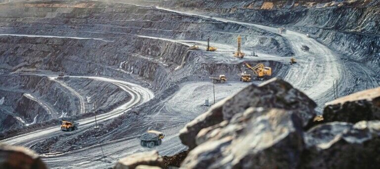 Work_of_heavy_equipment_in_an_open_pit_for_gold_ore_mining,_soft_focus