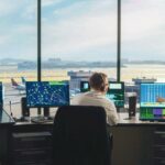 Diverse_Air_Traffic_Control_Team_Working_in_a_Modern_Airport_Tower._Office_Room_is_Full_of_Desktop_Computer_Displays_with_Navigation_Screens,_Airplane_Flight_Radar_Data_for_Controllers.