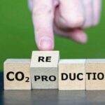 Hand_turns_wooden_cube_and_changes_the_expression_'CO2_production'_to_'CO2_reduction'.