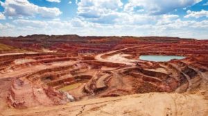 Aluminium_ore_quarry_and_blue_lake_in_bauxite_mine._Open_cast_(open-cut)_mining._Panorama_view._On_blue_sky_with_clouds_in_a_summer_day.
