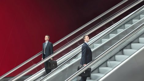 business_man_going_up_and_down_escalators,_concept_of_choice_and_success