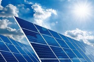 Two_large_solar_panels_under_the_blue_sky_with_the_sun_and_clouds