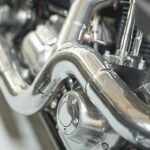 Chrome_plated_bend_exhaust_outlet_pipe_of_a_modern_motorbike._An_engine_block_with_the_exhaust_pipe_of_the_latest_motorcycle._Motorcycle_engine_clutch_casing_with_shiny_chrome_parts_closeup_detail.